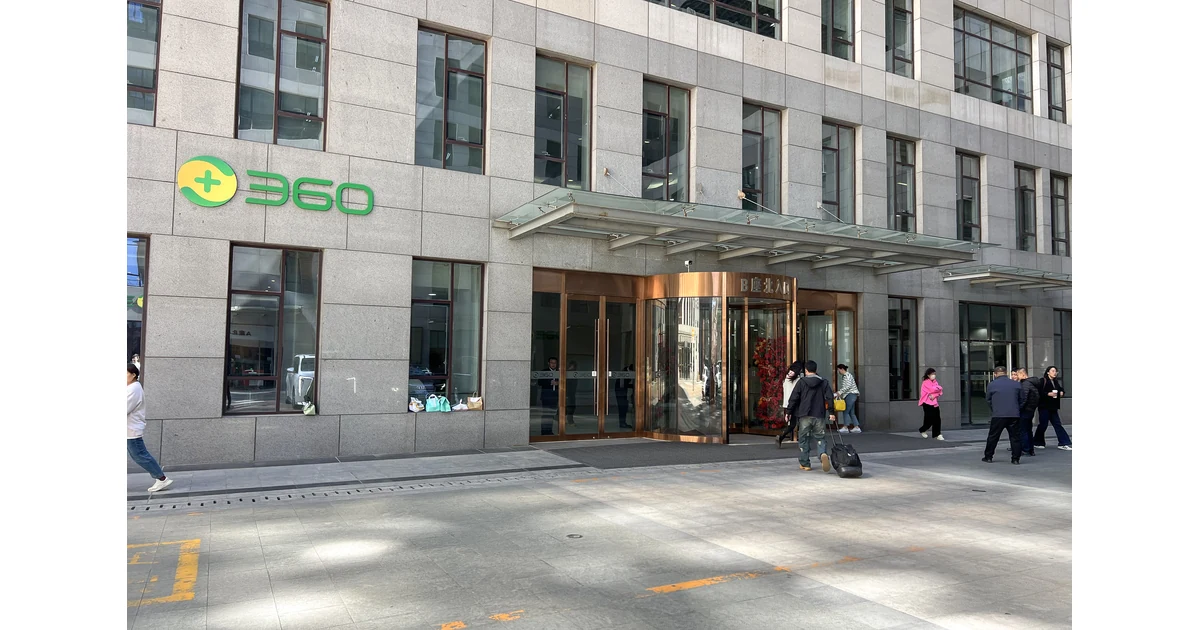 Entrada de edifício comercial com fachada de pedra e porta giratória.