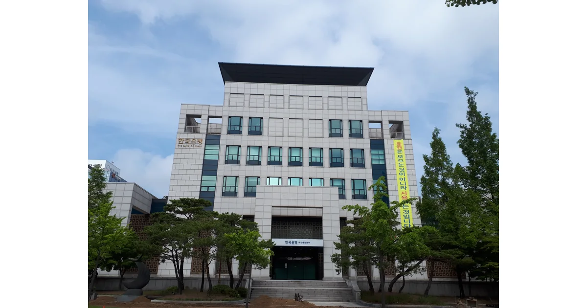Edifício em Daejeon com árvores e letreiros na fachada.