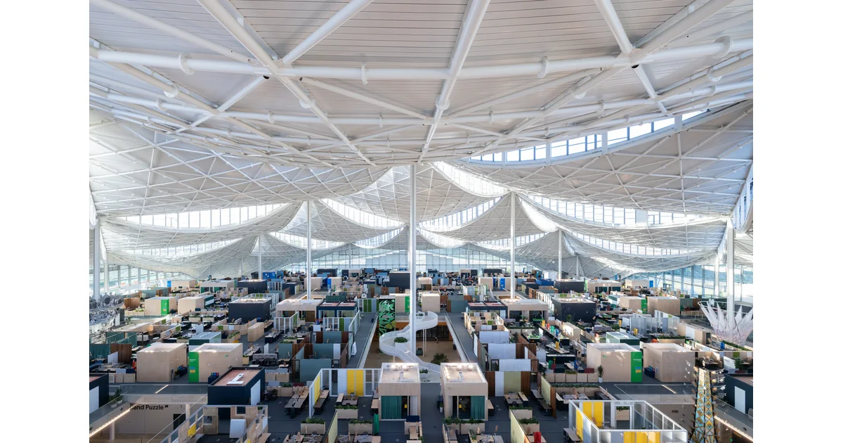 Interior do edifício Google Bay View, com áreas de trabalho sob a cobertura.
