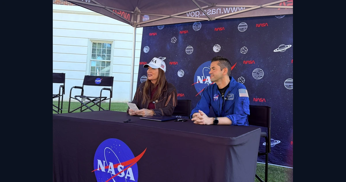 Brooke Rollins e Jared Isaacman sentados à mesa com documentos durante a cerimônia do acordo NASA e USDA