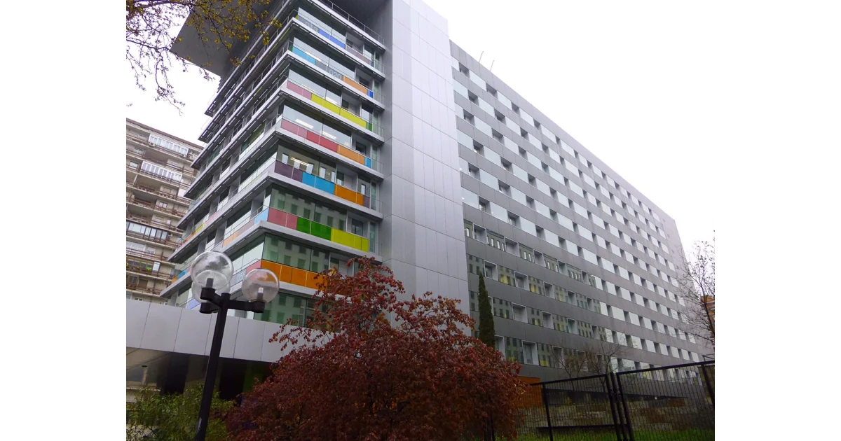 Edifício do INE em Madri, com fachada de painéis coloridos e janelas.